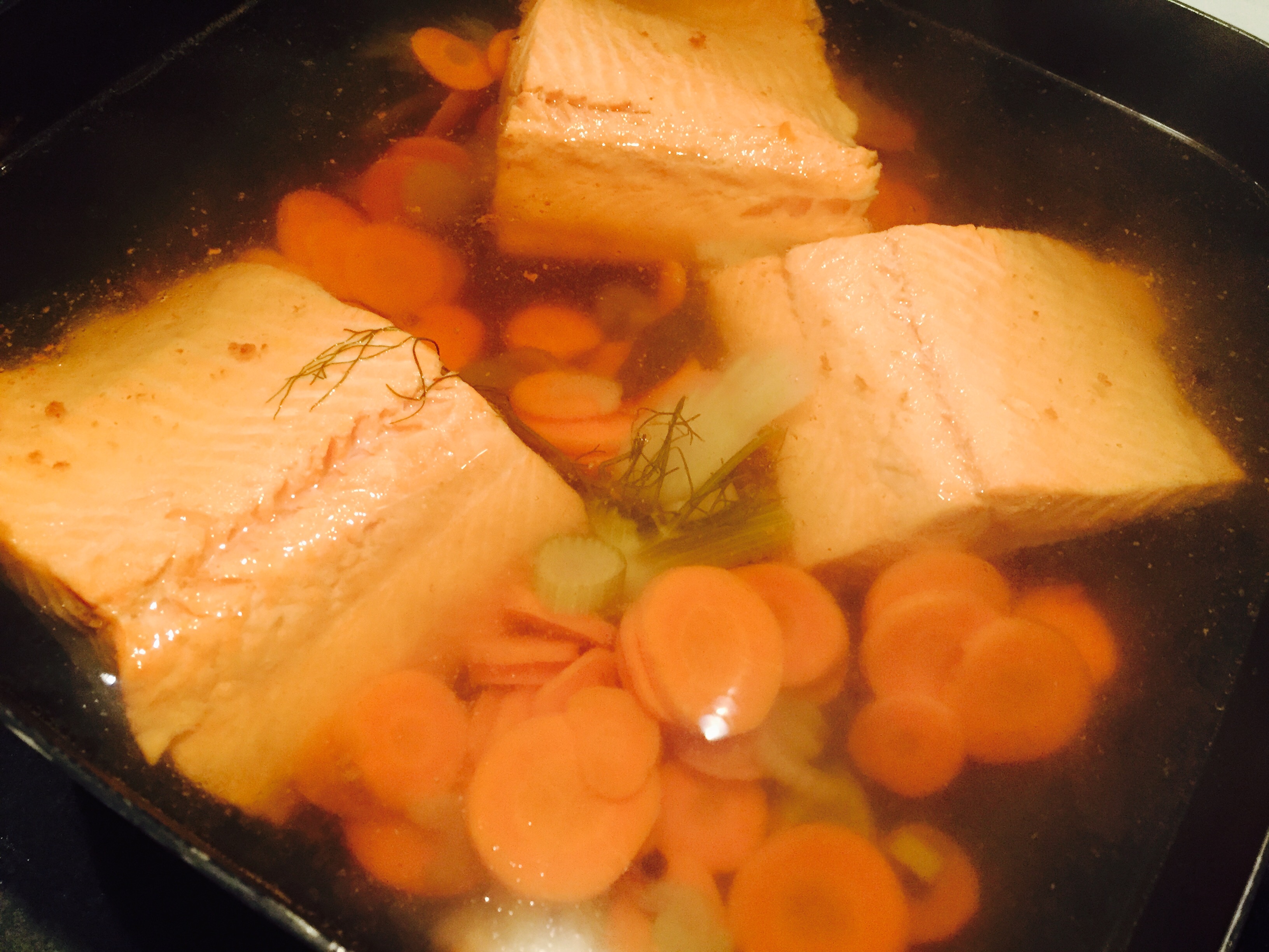 Trout simering in flavourful poaching mixture