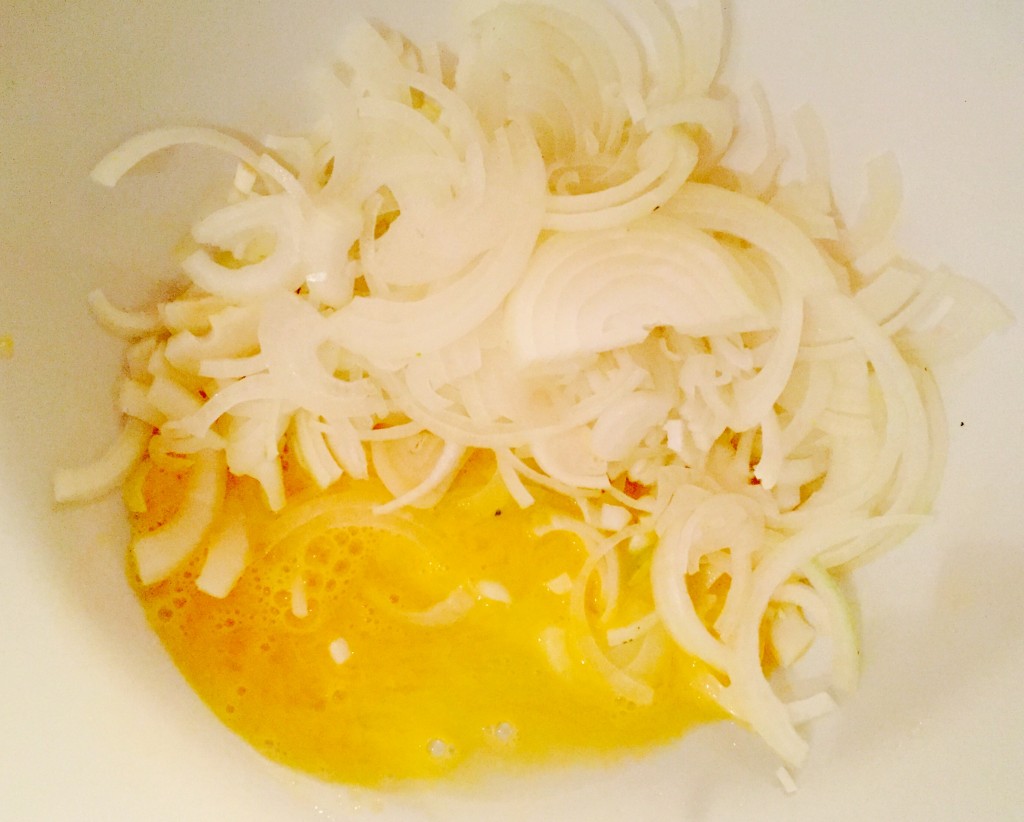 Thinly sliced onions and eggs ready to mix into a batter