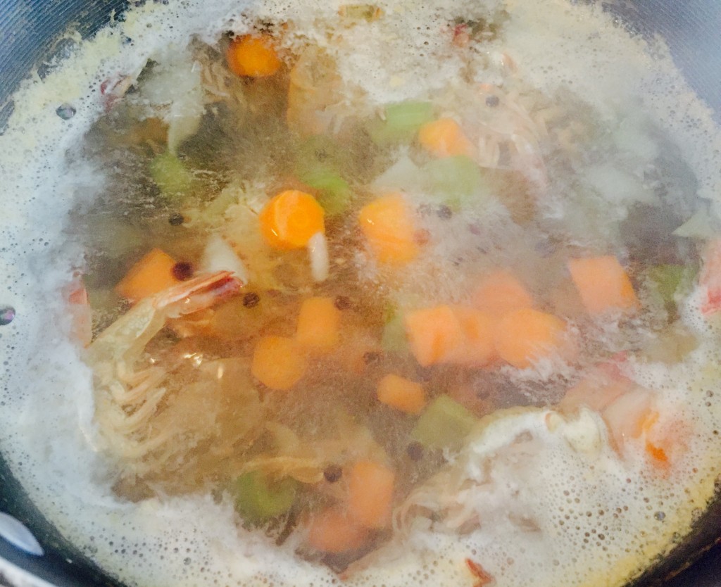 Savoury shrimp broth boiling gently in the pot