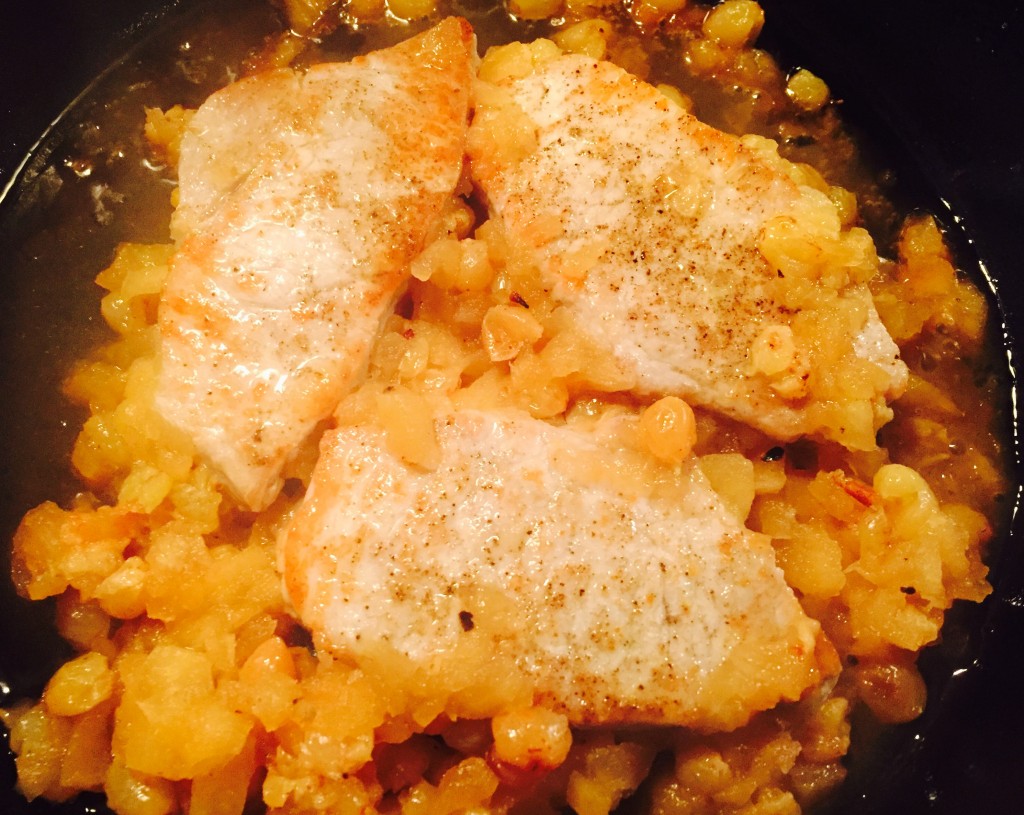 Delicious organic pork chops simmering in a fragrant apple & raisin sauce