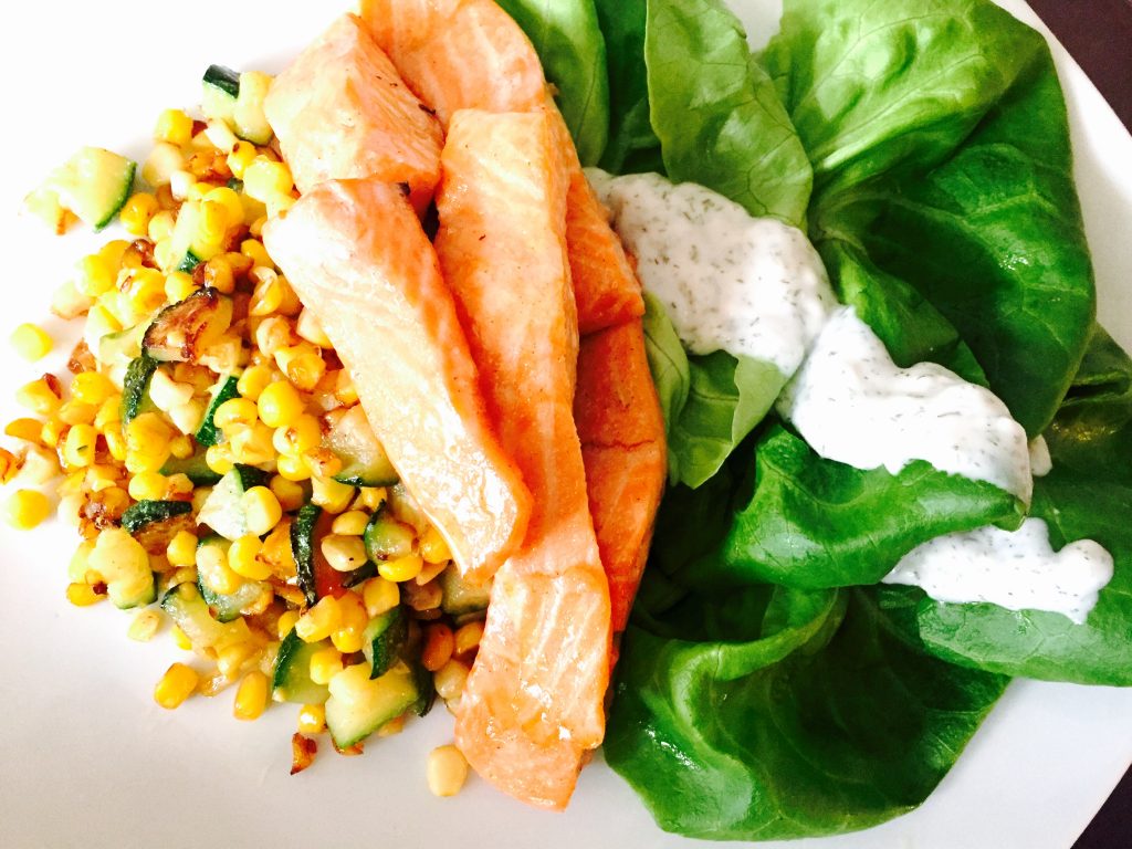 Tender slices of baked trout on corn &amp; zucchini hash with boston lettuce salad