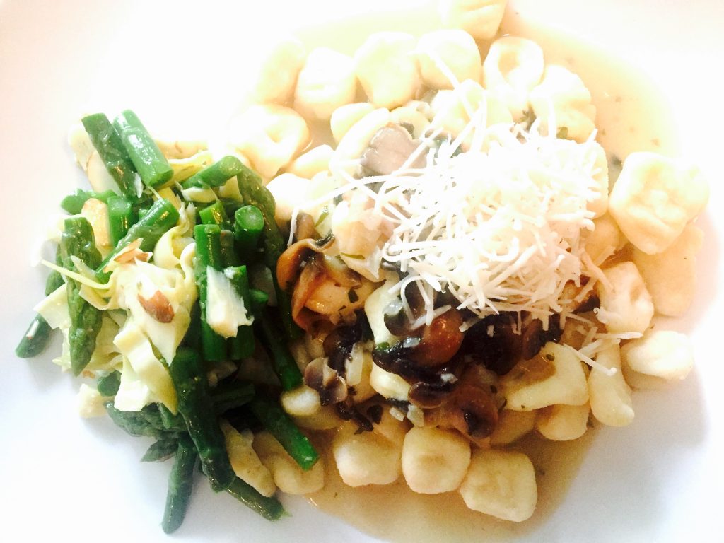 Home-made gluten free gnocchi in a dairy free creamy mushroom sauce with artichoke and asparagus salad