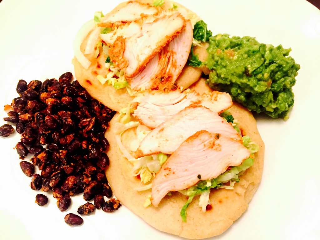 Delicious Salvadoran pupusas topped with curtido & sliced roast chicken and accompanied by yummy roasted black beans and fresh home-made guacamole