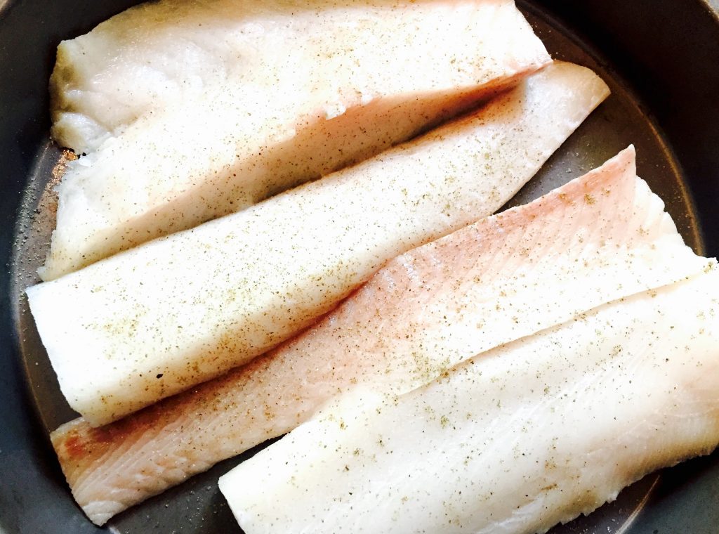 A large, fresh cod fillet cut into serving-friendly portions, then seasoned with kosher salt & freshly ground black pepper