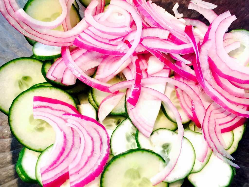 Fresh cucumbers and red onions sliced paper then