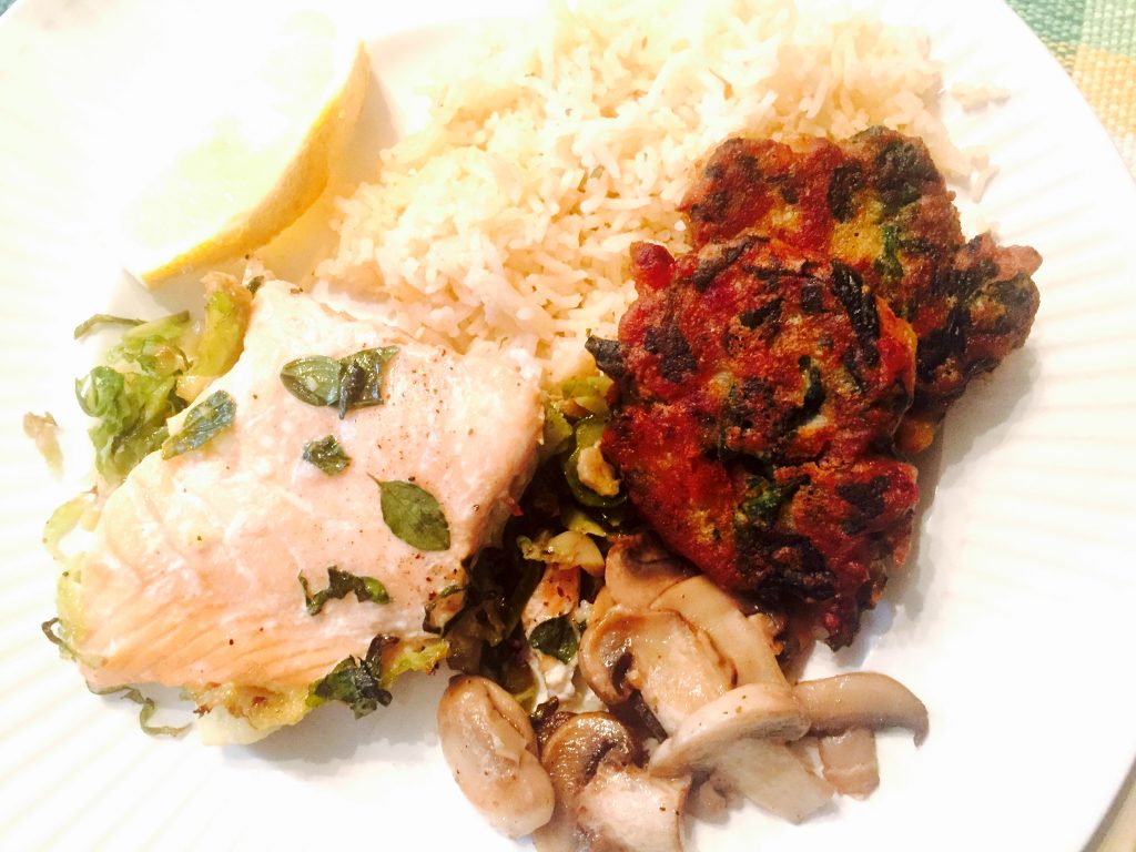 Baked salmon on thinly sliced roasted Brussel sprouts with yummy Callaloo fritters