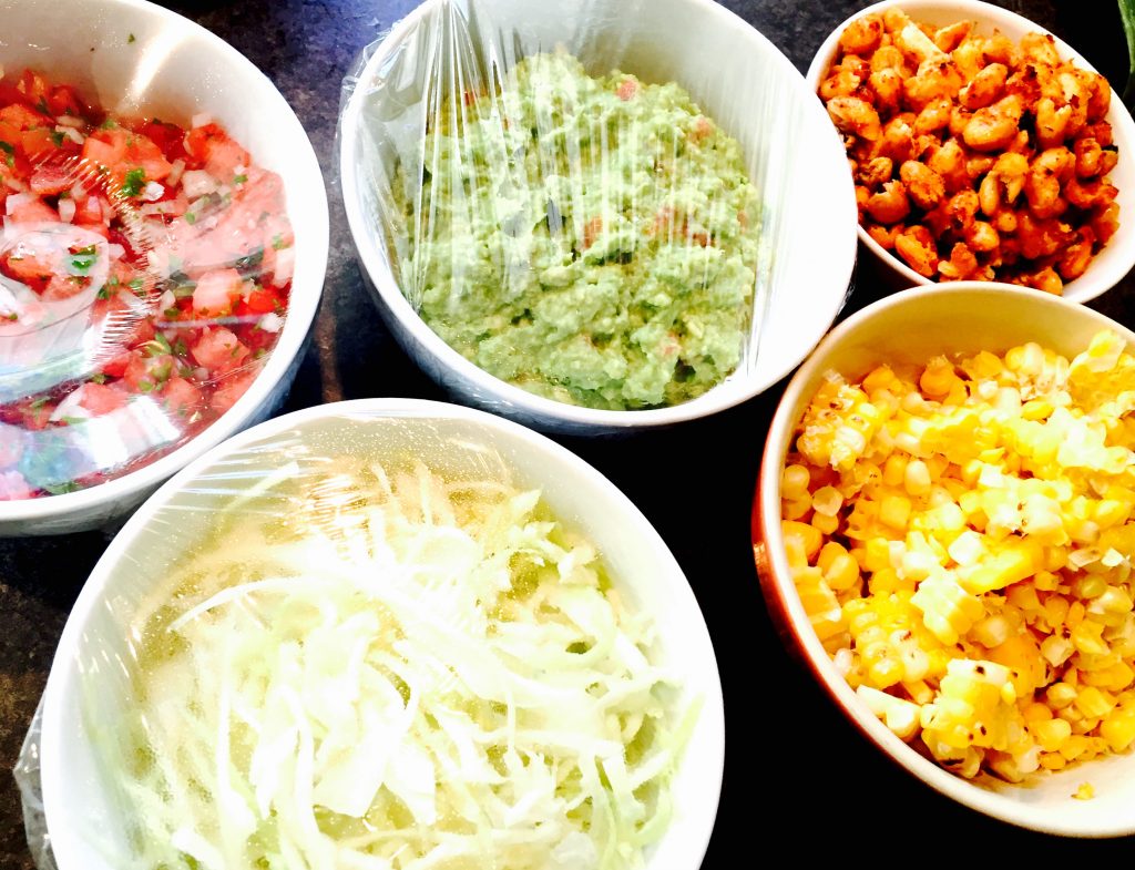 Home made salsa fresca & guacamole, some freshly shredded cabbage in a light vinaigrette, whole roasted then grilled corn off the cob, and some roasted white beans with sweet chilli seasoning