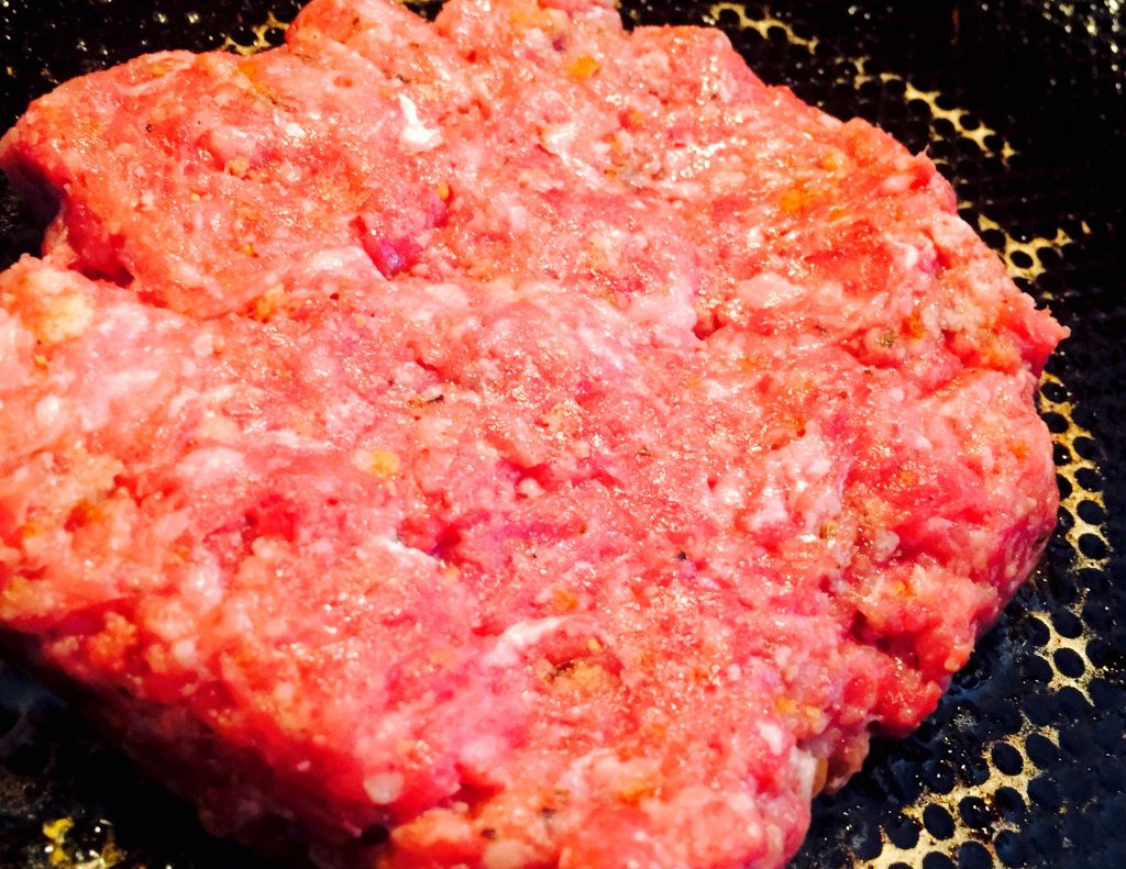 Wonderfully aromatic organic gluten free burger grilling in the skillet