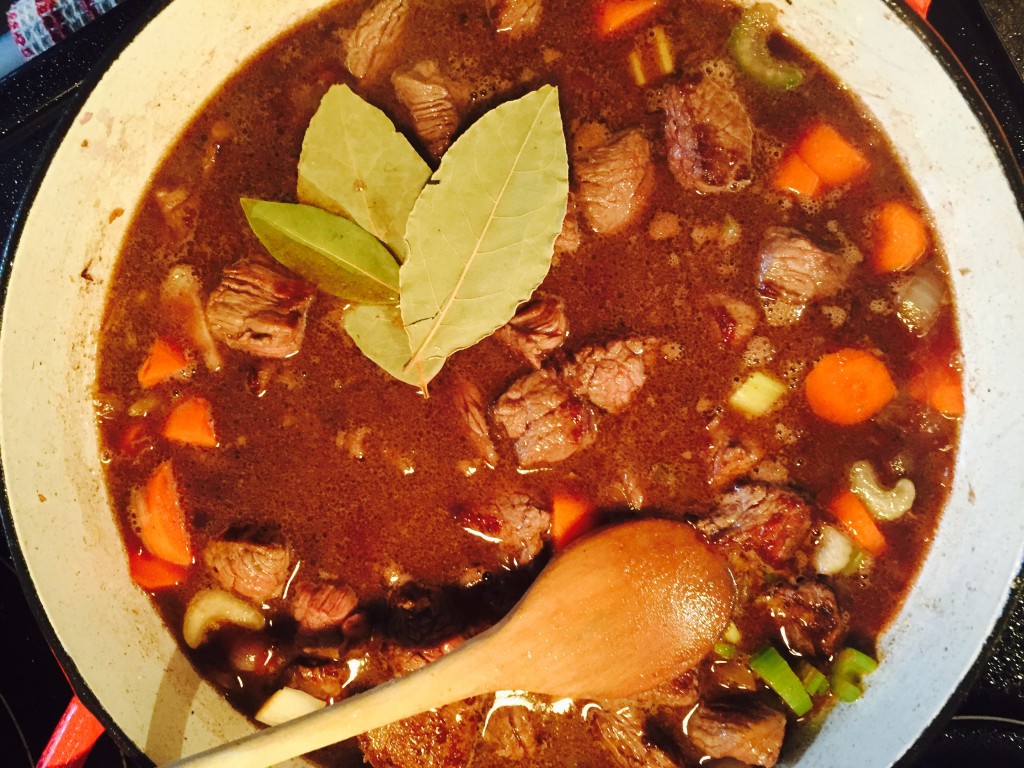 Delicious braised organic beef stew simmering in a dutch oven