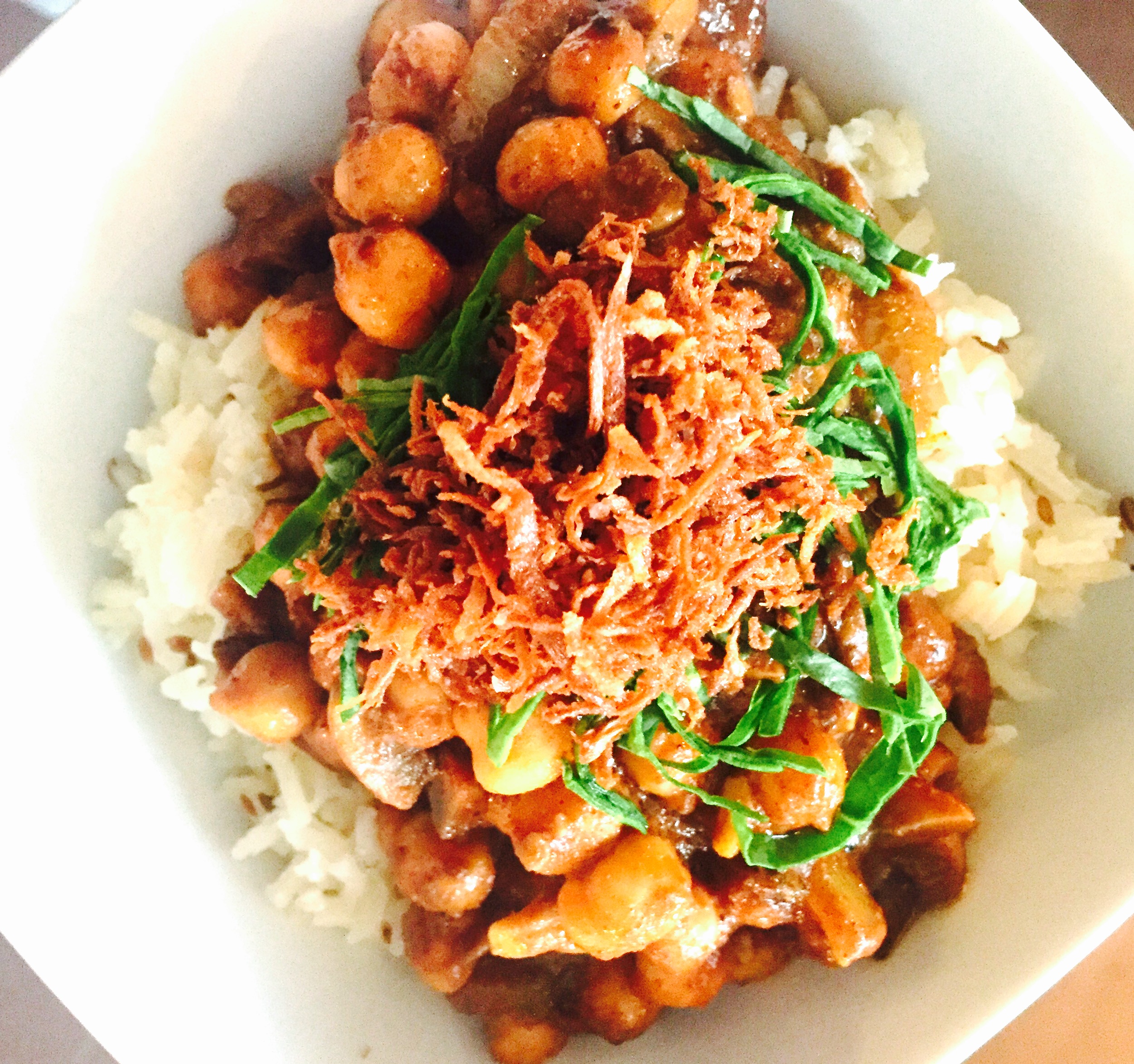 Savoury chana masala served on toasted cumin seed basmati with shredded baby spinach and deep fried grated parsnip