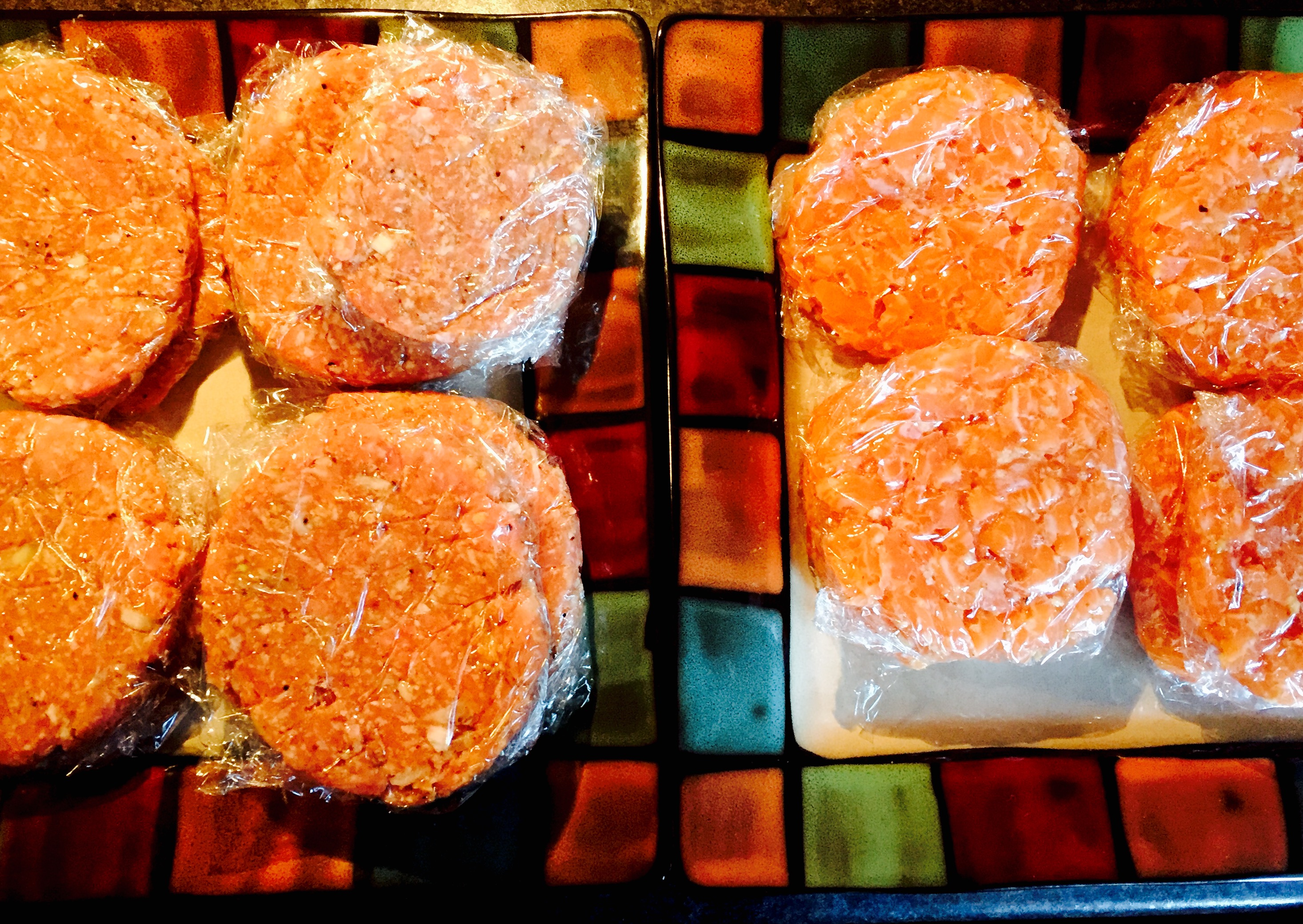 A fresh batch of homemade burgers ready for the deep freeze, pork on the left, salmon on the right