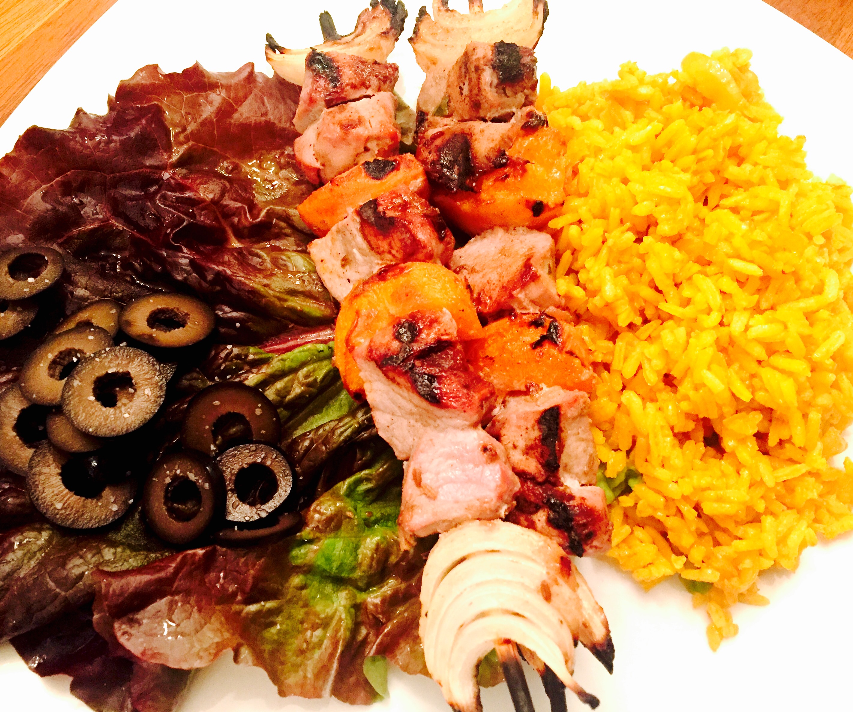 South African pork tenderloin sosaties with turmeric rice and salad greens