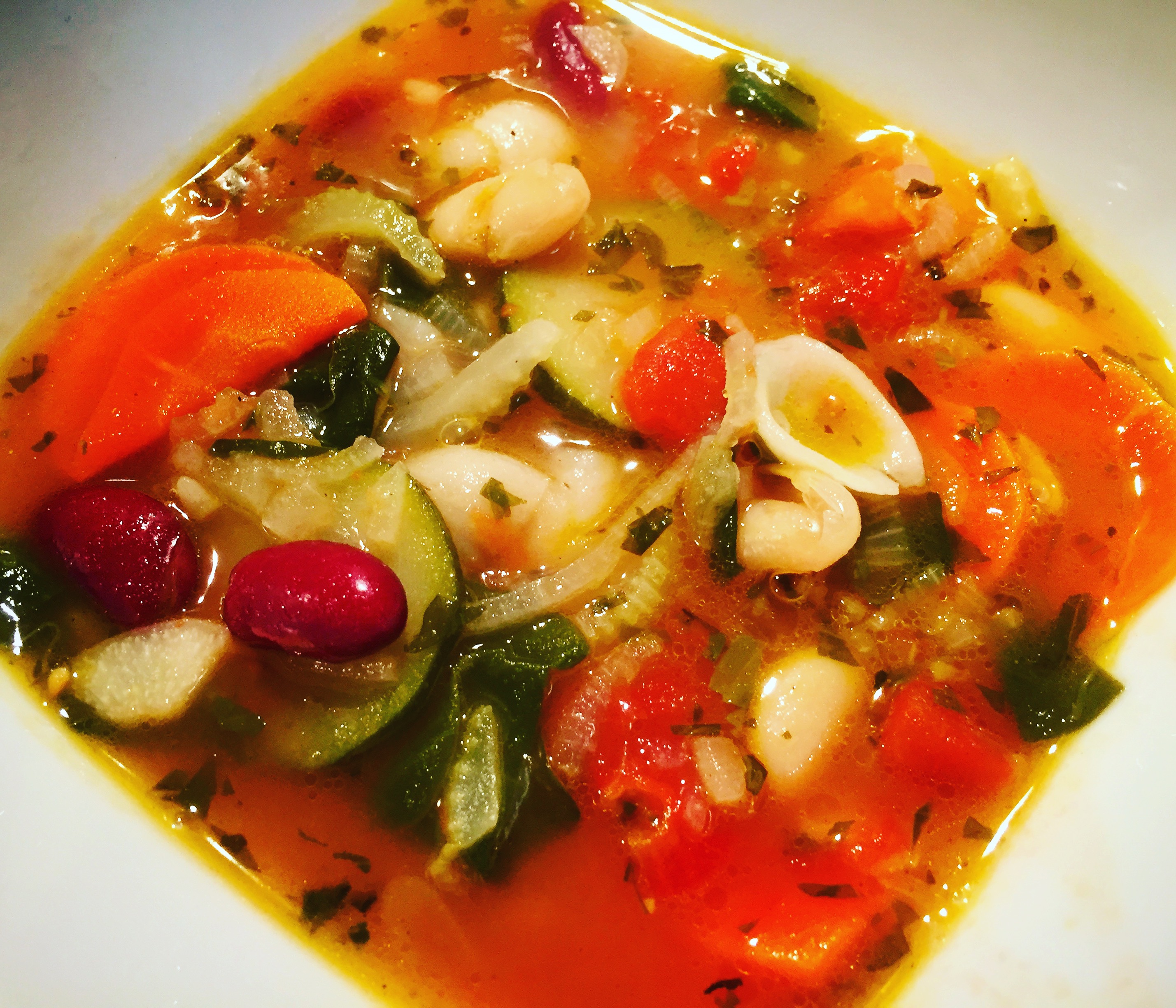 Delicious home made vegetarian minestrone soup with fresh herbs and garden vegetables
